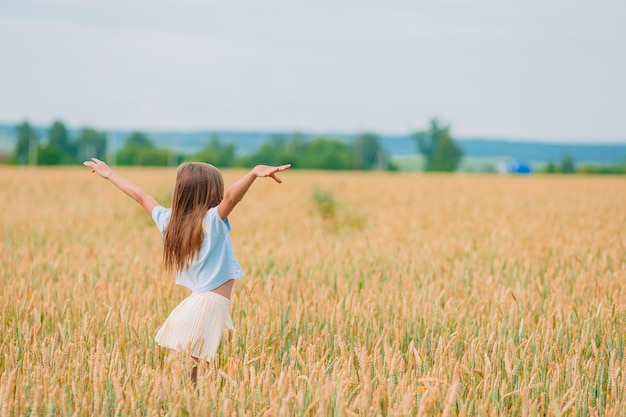 Meisje op gouden gebied in de zomer