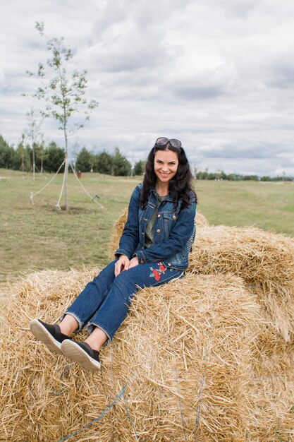 Meisje op hooischoven in de zomer met mooi donker haar