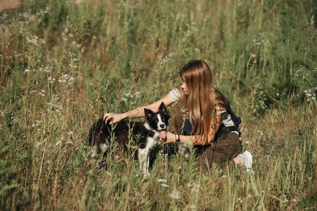 Meisje opleiding zwart-wit bordercollie hond pup