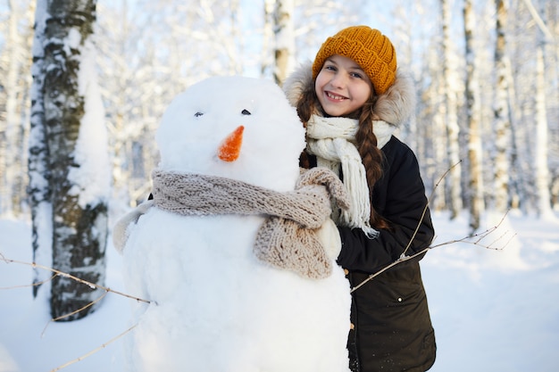 Meisje poseren met sneeuwpop
