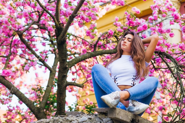 Meisje poseren met tak bloemen buiten