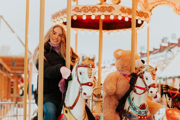 meisje rijdt op een carrousel met paarden