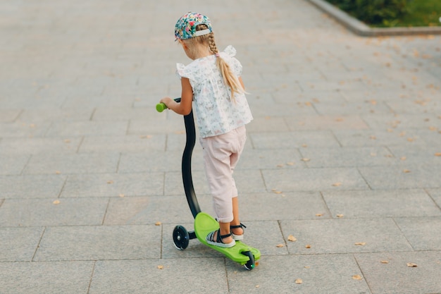 Meisje rijdt op een scooter op straat in de stad.