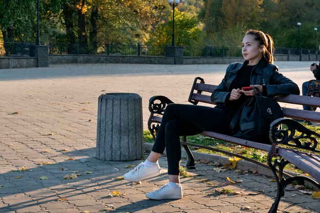 Meisje rust in het park op bankje op zonnige herfstdag.