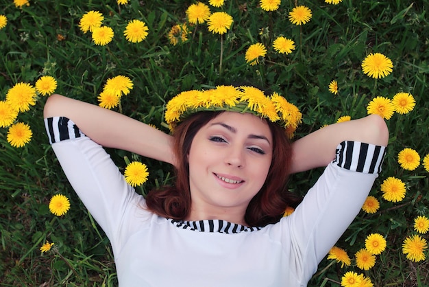 Meisje rust op een zonnige dag in een weide van gele paardebloemen