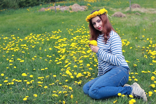 Meisje rust op een zonnige dag in een weide van gele paardebloemen