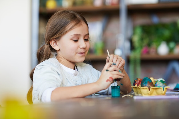 Meisje schilderij eieren voor pasen