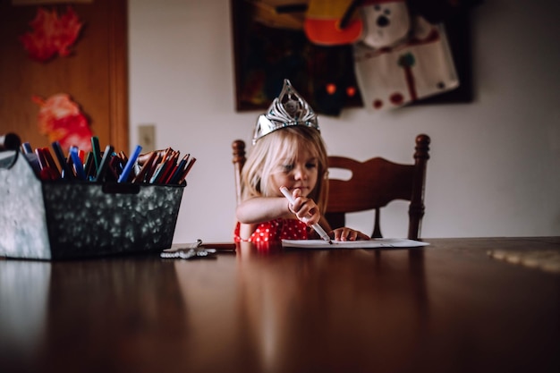 Meisje schildert op papier aan tafel.