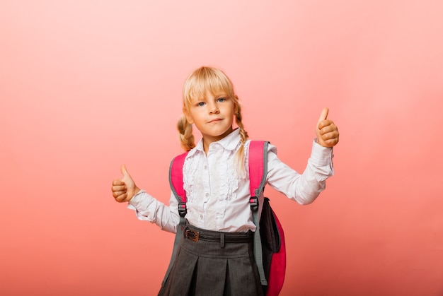 Meisje schoolmeisje toont gebaar van goedkeuring van de klas met beide handen geïsoleerd op roze achtergrond.