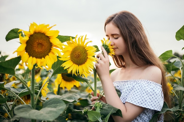 Meisje snuift geel boeket van bloeiend zonnebloemveld