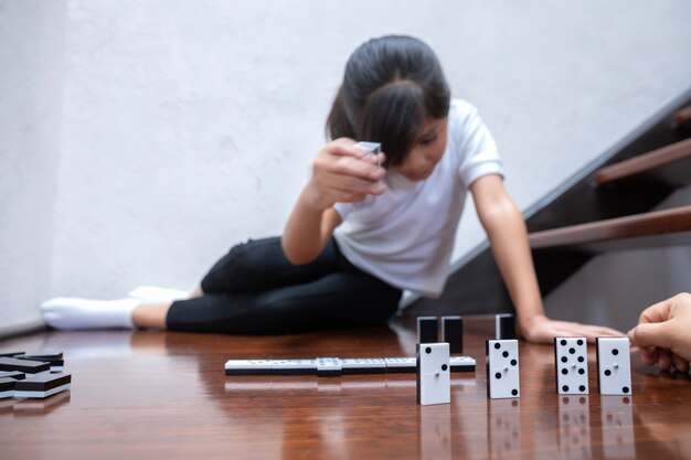 Meisje speelt domino in het huis