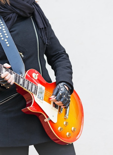 Meisje speelt een elektrische gitaar op witte achtergrond