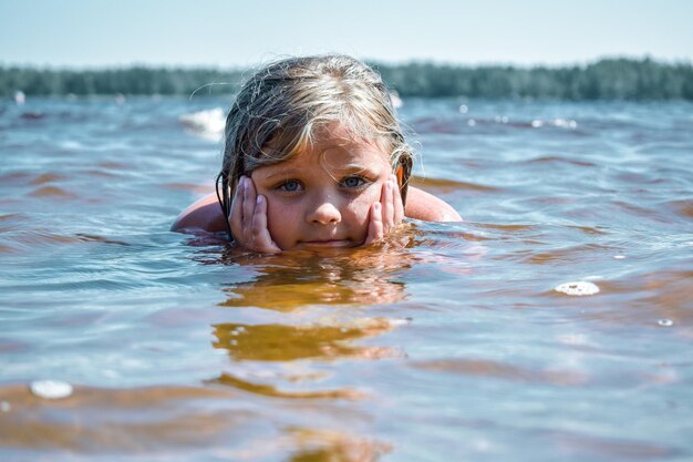Foto meisje speelt in het meer.