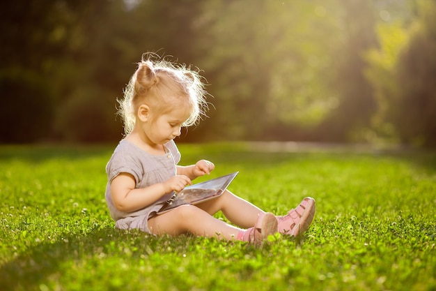 Meisje speelt met een tablet in het park