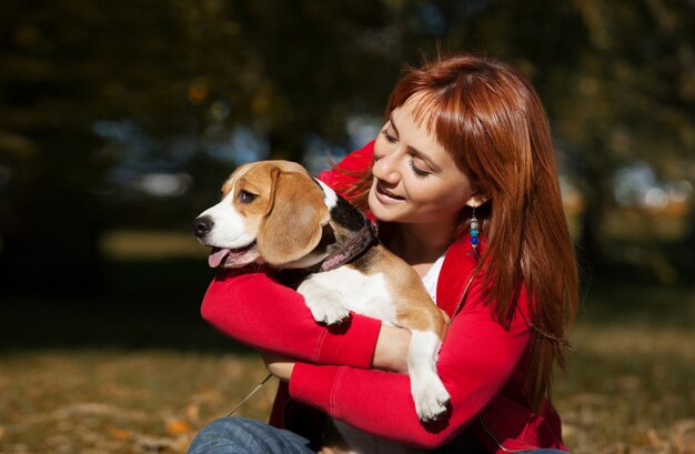 Meisje speelt met haar hond in de herfst park