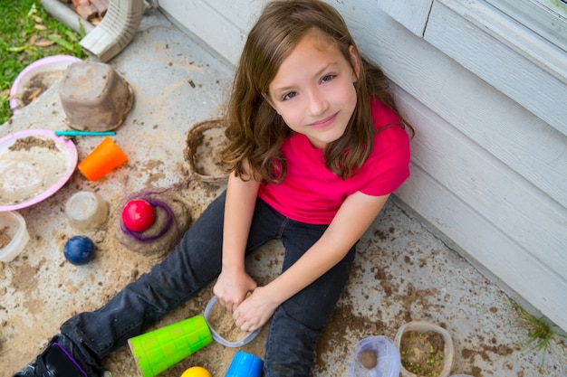meisje speelt met modder in een rommelige grond lachend portret