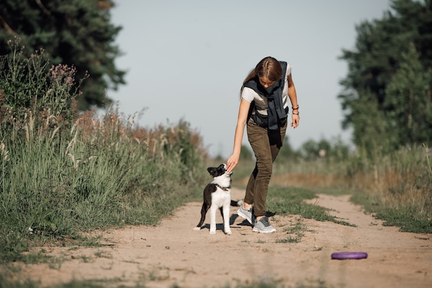 Meisje speelt met zwart-wit Bordercollie hond puppy op het bospad