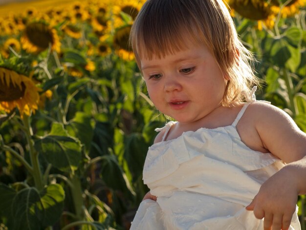 Meisje spelen in zonnebloem veld.