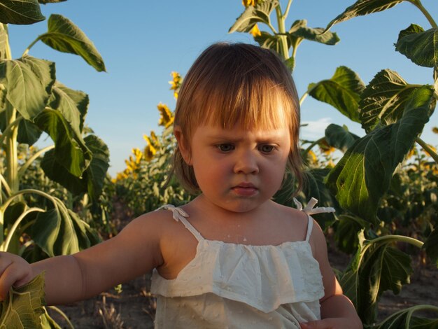 Meisje spelen in zonnebloem veld.