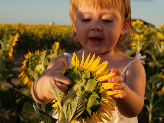 Meisje spelen in zonnebloem veld.