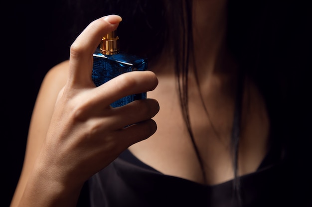 Foto meisje sprenkelt parfum over zichzelf
