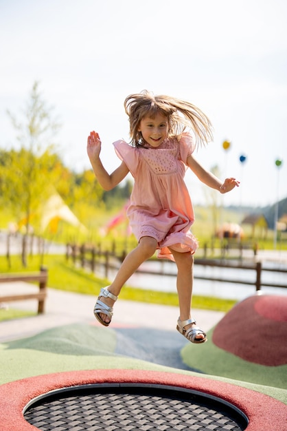 Meisje springen op opblaasbare trampoline in pretpark