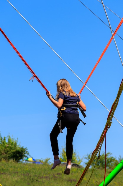 Foto meisje springt op bungee-trampoline