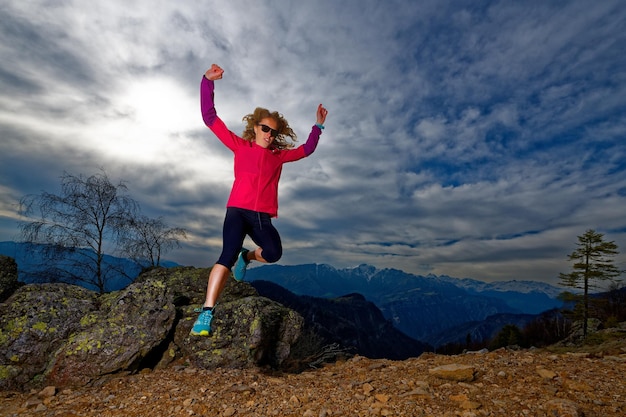 Meisje springt van rotsen in de bergen tijdens een training