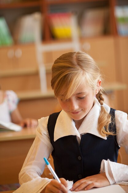 Meisje studeert in de klas aan de balie