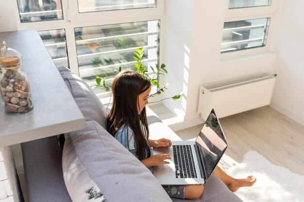 Meisje studeert online met behulp van haar laptop thuis