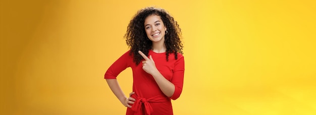 Meisje suggereert nieuwe productvriendelijke en aangename gelukkige jonge europese brunette met gekrulde h uit te proberen