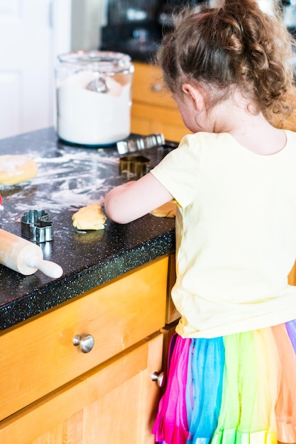 Meisje suikerkoekjes bakken in de keuken.