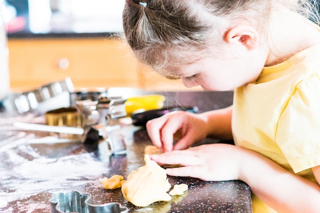 Meisje suikerkoekjes bakken in de keuken.