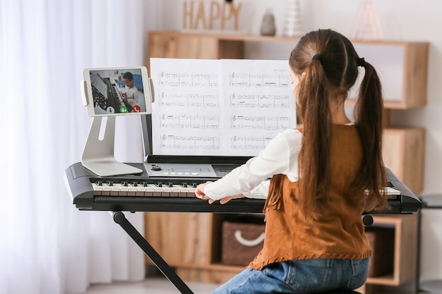 Meisje thuis muziek studeren met haar vriend online