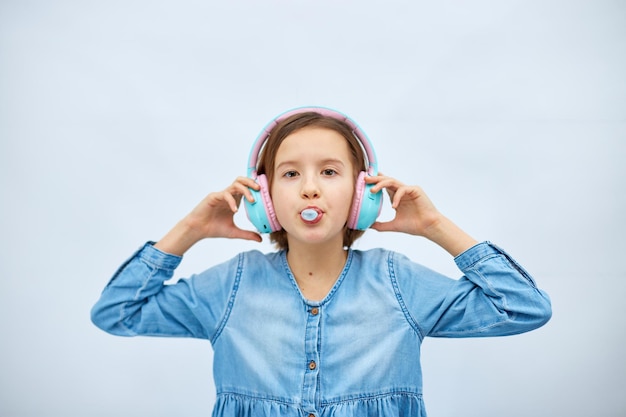 Meisje tiener met kauwgom luisteren naar muziek in koptelefoon