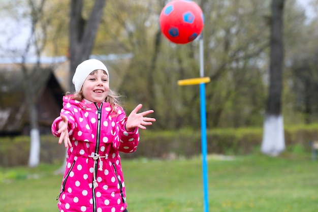 Meisje vangt de bal.Kinderspellen op straat