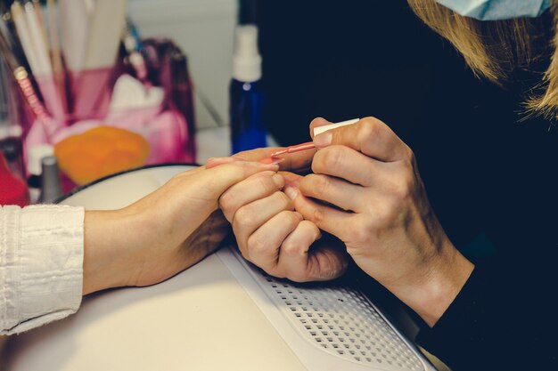 Meisje verf nagels in de salon van manicure close-up