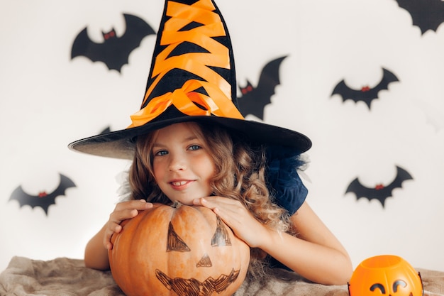 Meisje verkleed als heks met een pompoen. halloween. pompoen voor halloween