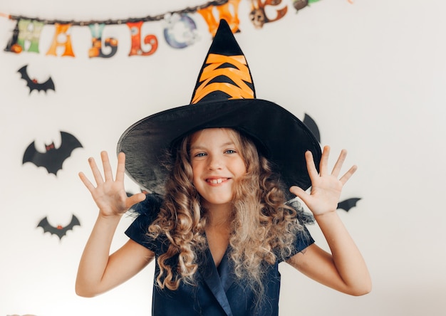 Meisje verkleed als heks met een pompoen. halloween. pompoen voor halloween