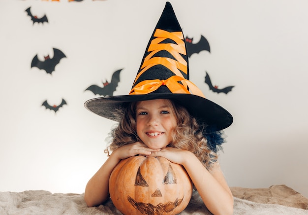 Meisje verkleed als heks met een pompoen. halloween. pompoen voor halloween