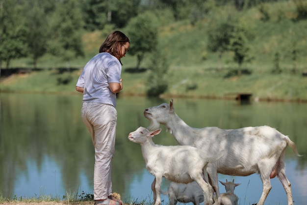 Meisje voedt en speelt met geiten op een boerderij