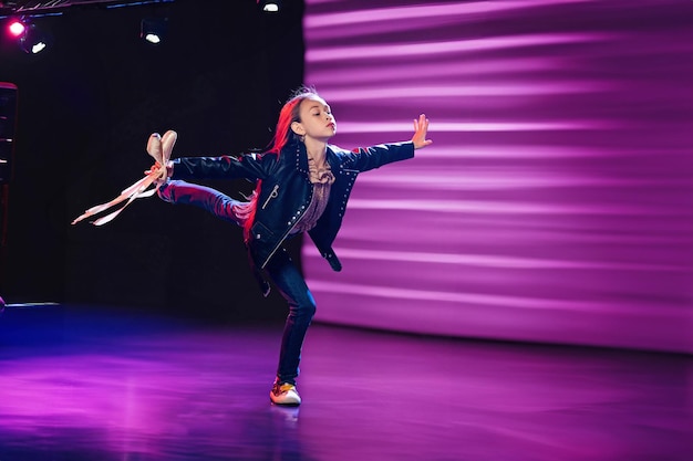 Meisje voert moderne choreografie uit met pointe schoenen in haar handen Verschillende richtingen in de danskopie ruimte