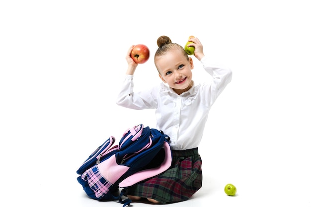 Meisje voor de gek houden met fruit zittend op een witte achtergrond