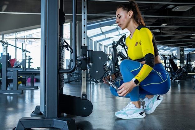 Meisje voorbereiding kabel crossover machine voor oefening op sportschool exercise