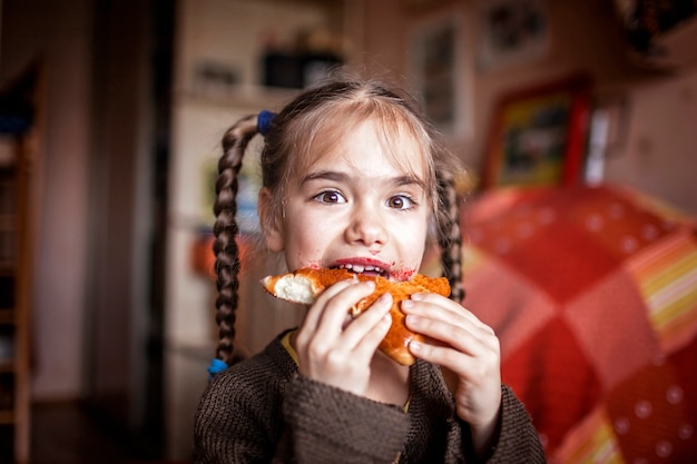 Meisje vuil met bessenjam eten zelfgemaakte pasteitje, indoor emotionele levensstijl portret