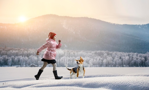 Meisje wandelen met hond in de winter. Gemengde media