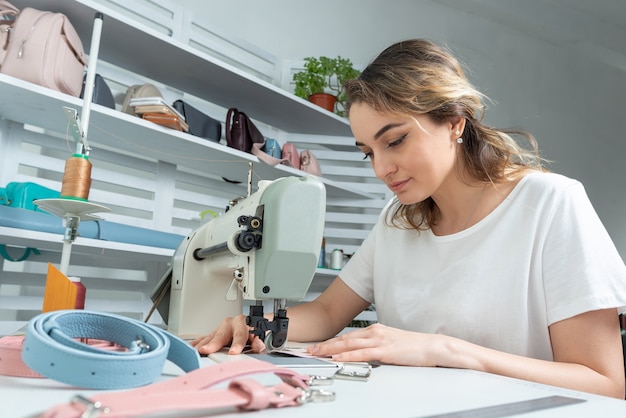 Meisje werknemer naait op een naaimachine