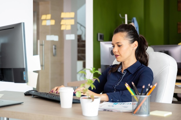 Meisje werkt op de computer. Kijk naar toetsenbord