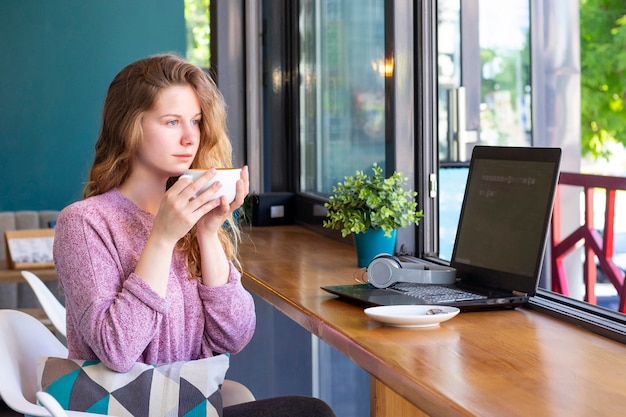 Meisje werkt vanaf een laptop in een coffeeshop