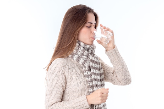 Meisje wordt ziek en drinkt pilwater geïsoleerd op een witte achtergrond